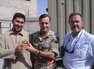 John presenting Lt Col Tim Purbrick with a pot of Helmand honey with Don Welty on the right